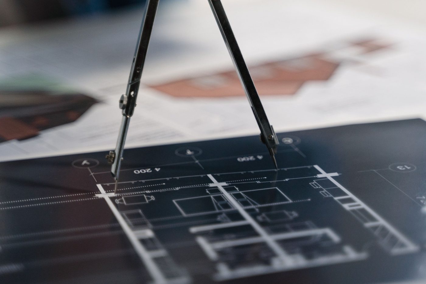 Architect’s compasses resting on a blueprint of a building plan